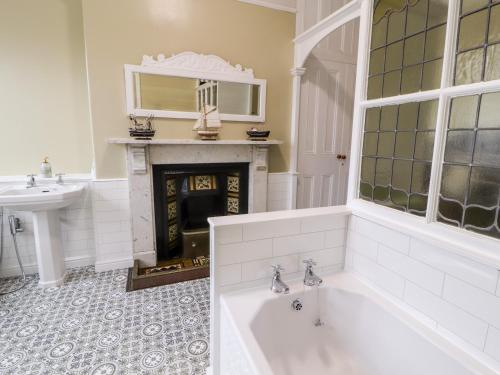 a bathroom with a bath tub and a fireplace at 23 Chatsworth Square in Carlisle