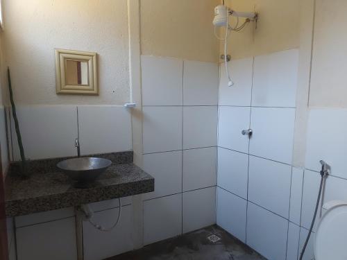 uma casa de banho com um lavatório e um espelho em Casas e apartamentos da Praia, Lapinha na beira do lago em Santana do Riacho