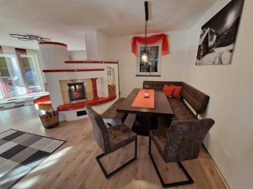 a living room with a dining table and a fireplace at DSW Ferienhaus in Oberperfuss