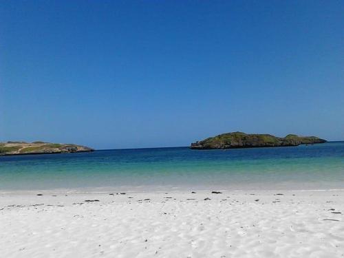 a white beach with two islands in the water at BeB Sardegna2 Anjumasa village in Watamu