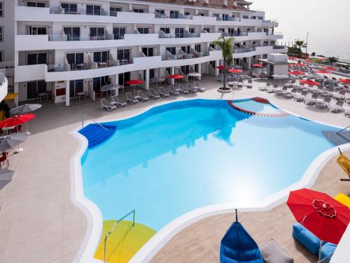 an overhead view of the pool of a hotel with chairs and umbrellas at Sholeo Lodges Los Gigantes in Puerto de Santiago