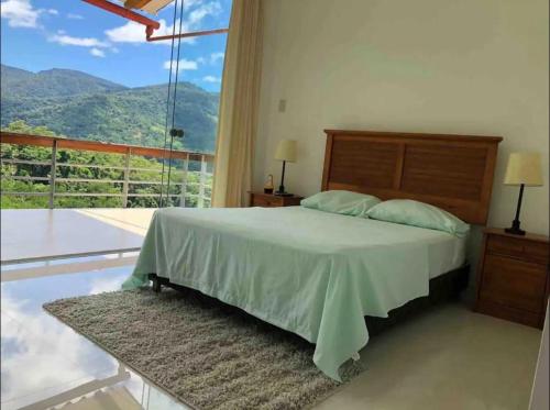a bedroom with a bed and a large window at Vista escalera lodge in Tarapoto