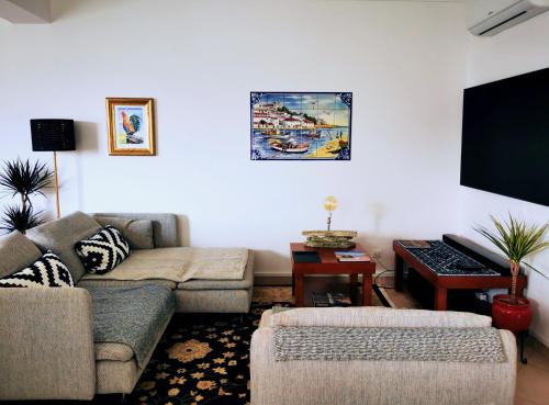 a living room with a couch and a flat screen tv at #056 Old Post Office by Home Holidays in Albufeira