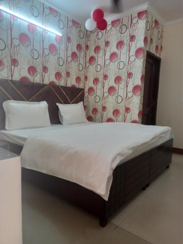 a bedroom with a bed with red flowers on the wall at Hotel king palace in Chandīgarh