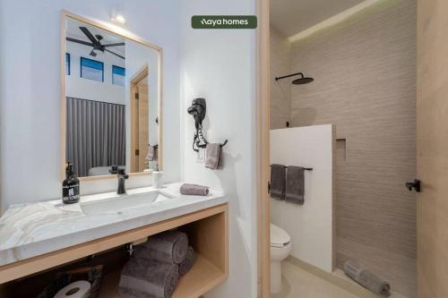 W łazience znajduje się umywalka, toaleta i lustro. w obiekcie Condo near Marina - Downtown - Pool - King w mieście Cabo San Lucas