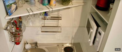 une petite cuisine avec un évier et un comptoir dans l'établissement Appartement cœur vieille ville, à La Rochelle