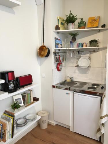 une cuisine avec des étagères blanches et un évier dans l'établissement Appartement cœur vieille ville, à La Rochelle