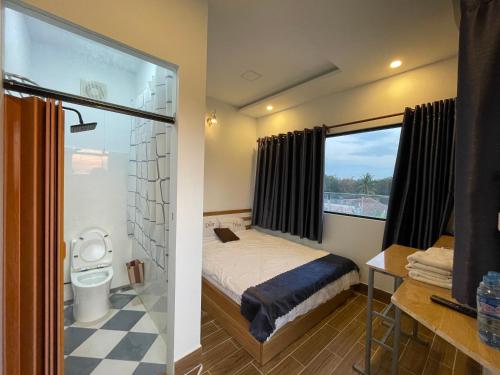 ein Schlafzimmer mit einem Bett und einer Dusche mit einem Fenster in der Unterkunft Ngoc An Hotel in Tây Ninh