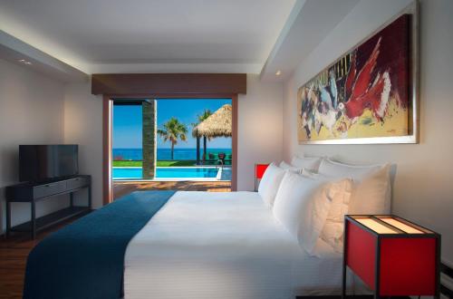 a bedroom with a bed with a view of the ocean at Porto Zante Villas And Spa in Tragaki