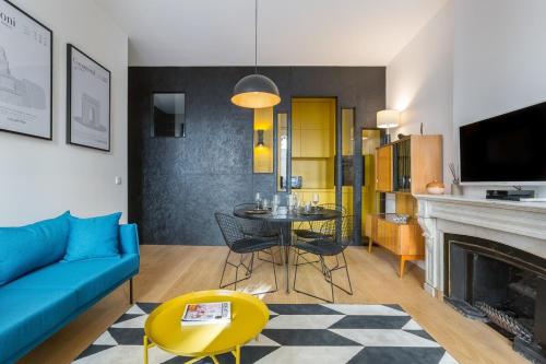 a living room with a blue couch and a fireplace at Hallmark - Location T2 - Lyon 2 in Lyon