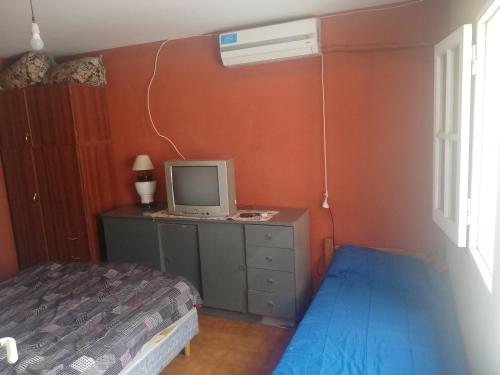 Un dormitorio con una cama y una computadora en un escritorio. en Cabañas San Gabriel Carlos Paz, en Villa Carlos Paz