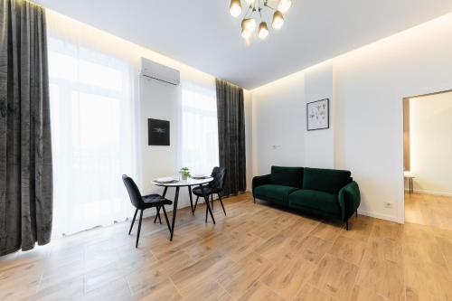 a living room with a green couch and a table at Luxury Apartments Laborca in Uzhhorod