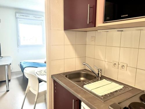 a kitchen with a sink and a counter top at Neoresid - Résidence Republique in Douai