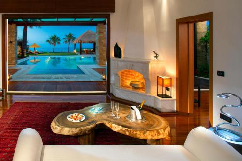 a living room with a table and a fireplace at Porto Zante Villas And Spa in Tragaki
