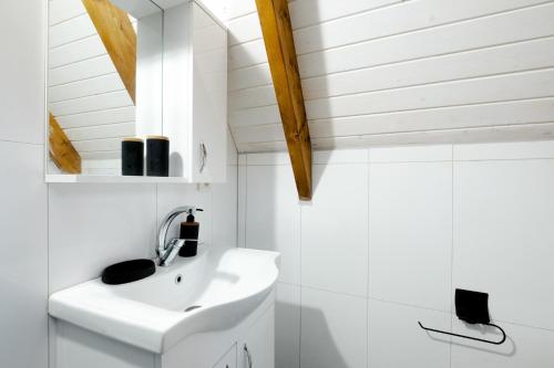 uma casa de banho branca com um lavatório e um tecto em Bungalow with Spacious Garden Right by the Sea em Yalova