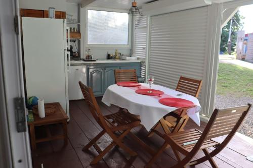 einen Tisch und Stühle in einer Küche mit einem Tisch in der Unterkunft La Petite Maison de Marie in Sainte-Marie