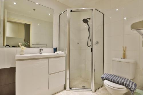 uma casa de banho com um chuveiro, um WC e um lavatório. em Vintage Charm Oasis - CBD Living with Parking em Sydney