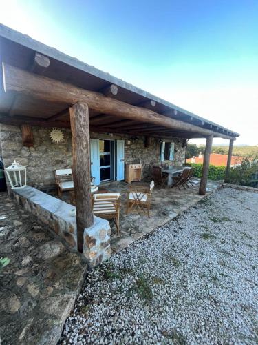 a stone house with a table and chairs in front of it at Stazzo Casa Bianco Fly in Aggius