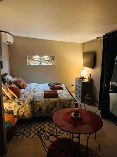 een slaapkamer met een bed en een tafel. bij Le Cocoon Lodge du Gapeau & Massage in Solliès-Pont