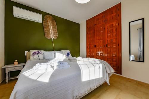 a large white bed in a bedroom with a green wall at Villas Guzman - Casa Nova in Moraira