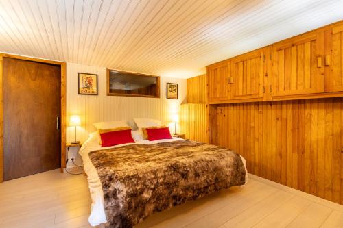 une chambre avec un grand lit avec des oreillers rouges dans l'établissement Chalet La Cora classé 4 étoiles pied des pistes Font-Romeu P2000, box WIFI, à Bolquère-Pyrénées 2000