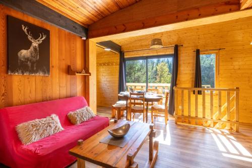 un salon avec un canapé rouge et une table dans l'établissement Chalet La Cora classé 4 étoiles pied des pistes Font-Romeu P2000, box WIFI, à Bolquère-Pyrénées 2000