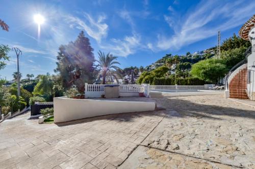 a stone patio with a white fence and trees at Villas Guzman - Casa Nova in Moraira