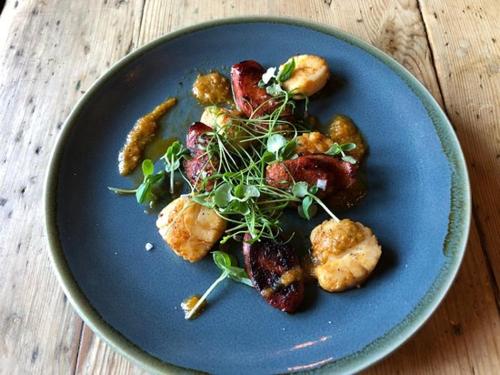 a blue plate with food on a wooden table at The Black Horse Inn in Maidstone