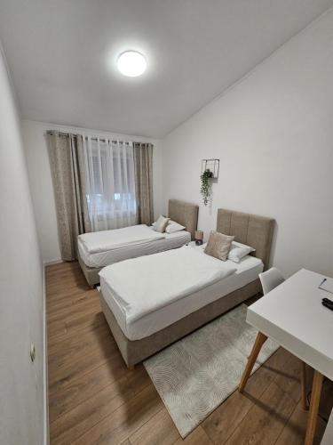 salon z 2 łóżkami i stołem w obiekcie Drava Osijek w mieście Osijek