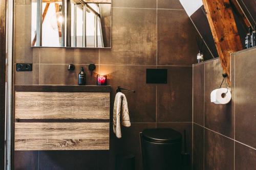 uma casa de banho com um WC e um espelho. em B&B Holm em Groningen