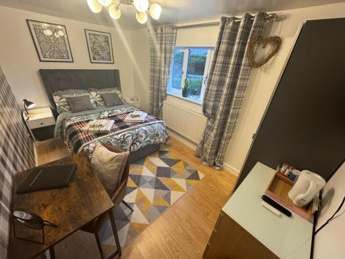 a bedroom with a bed and a table with a laptop at Brick lodge house in Castle Donington