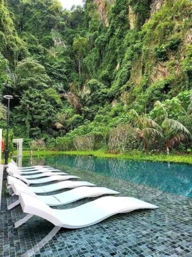 a row of loungers sitting next to a pool of water at IPOH TAMBUN THE COVE Your Ultimate Relaxation Getaway777 -3 BED ROOM -NO PETS ALLOW in Ipoh