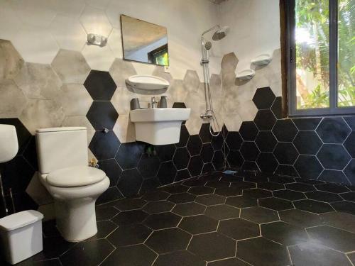 een badkamer met een toilet en een wastafel bij Escapade dans un jardin avec piscine in Lomé