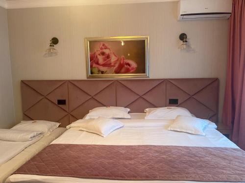 a bedroom with two large beds with white pillows at Hotel Roser House Boutique - pe malul lacului Colibita in Colibiţa