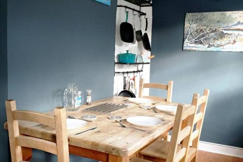 a dining room table with two chairs and a wooden table with plates at Entire house in Sherwood, Nottingham in Nottingham