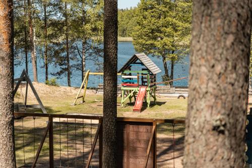 a park with a playground next to a lake at Kempings Bejas in Babīte