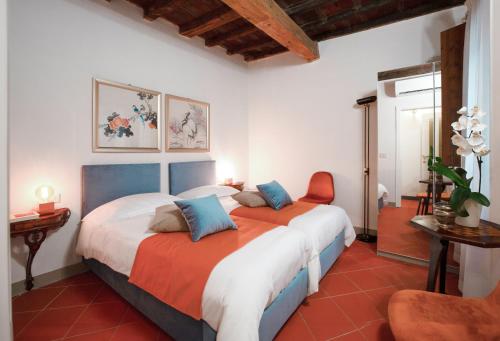 a bedroom with two beds with orange and blue pillows at Casa nel Centro Storico Firenze in Florence