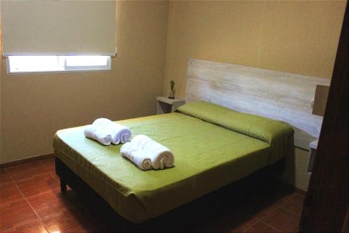 Kuyay Cabañas في سان رافاييل: غرفة نوم عليها سرير وفوط