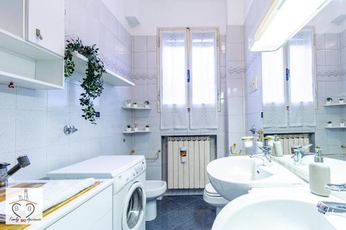 Baño blanco con lavabo y aseo en FamilyBO Apartments Murri - Self Check-in, en Bolonia