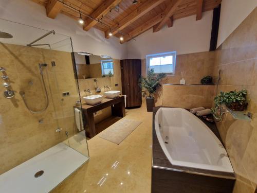 ein Bad mit einer Badewanne, einer Dusche und einem Waschbecken in der Unterkunft DSW Ferienhaus in Oberperfuss