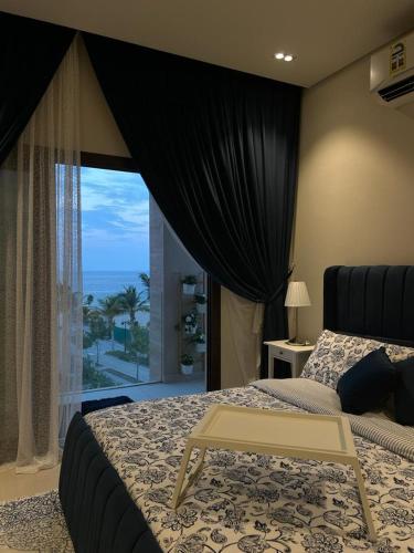 een slaapkamer met een bed en uitzicht op de oceaan bij Sifah Ocean Breeze Villa in Muscat