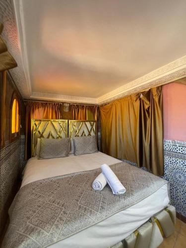 a bed with two towels sitting on top of it at Riad Malak in Meknès