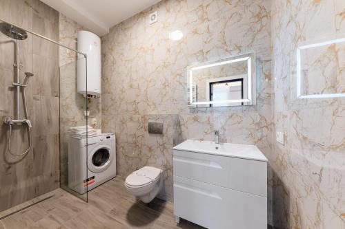 a bathroom with a toilet sink and a washing machine at Luxury Apartments Laborca in Uzhhorod