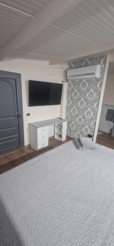 een slaapkamer met een bed en een flatscreen-tv bij Suites GREY in centro Randazzo in Randazzo