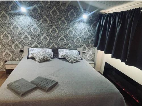 een slaapkamer met een bed met 2 kussens erop bij Suites GREY in centro Randazzo in Randazzo