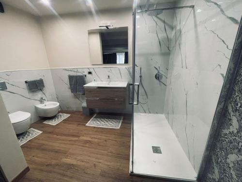 een badkamer met een douche, een wastafel en een toilet bij Suites GREY in centro Randazzo in Randazzo