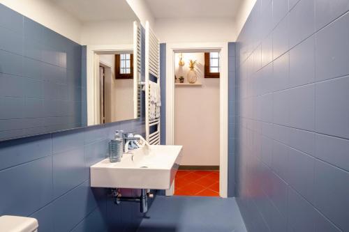 a bathroom with a white sink and a blue wall at Casa nel Centro Storico Firenze in Florence