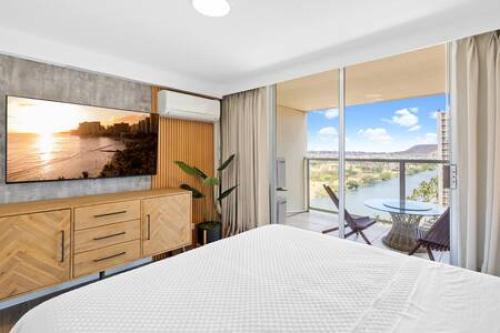 - une chambre avec un lit blanc et une grande fenêtre dans l'établissement NEWLY Remodeled Upscale Design Central Waikiki, à Honolulu