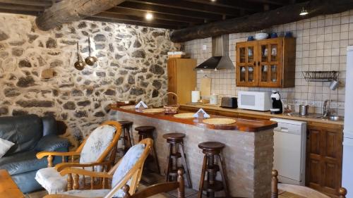 a kitchen with a bar with stools and a couch at Hotel La Casa Chacinera in Candelario