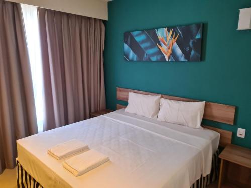 a bedroom with a large bed with two towels on it at Ideal para famílias, hospede-se no Solar das Águas. in Olímpia